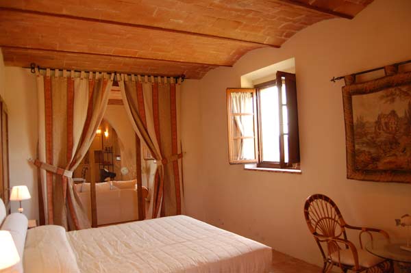 Camera da letto posta al piano terra della villa con grande arco con finestra